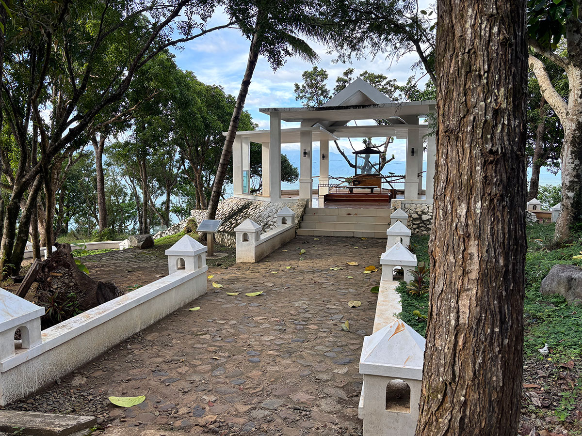 Mini chapel at Ermita Hill surrounded by trees with a view of the ocean in the background